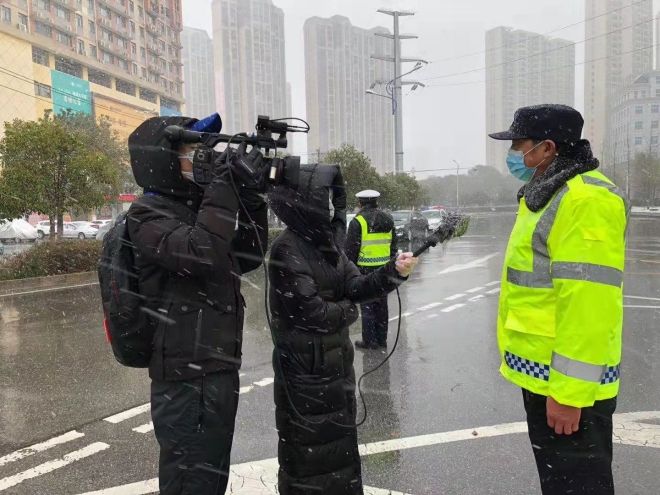 孝感市融媒體中心楊亞玲（風(fēng)雪中，采訪疫情期間重返一線的退休警察）_副本.jpg.jpg